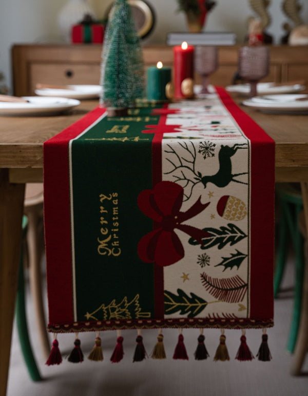 Camino de mesa con borlas y lazo con ambiente navideño