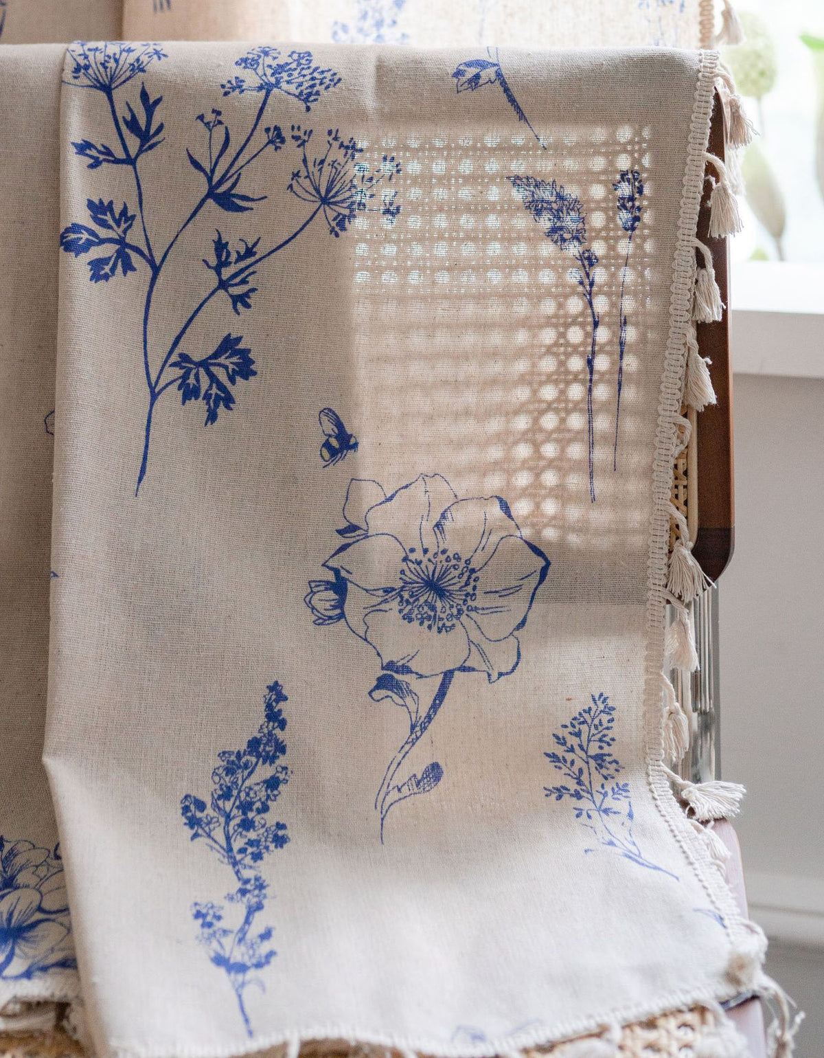 Cortina con estampado de flores azules y borde con borlas beige 